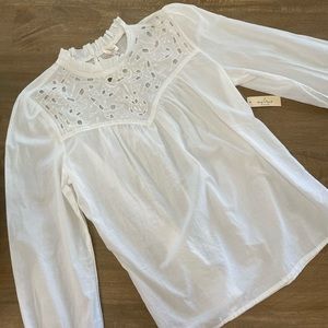 White blouse with cutout embellishment.
